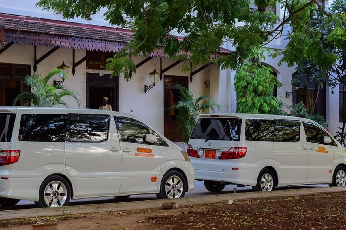 dua buah van putih diletakkan di hadapan sebuah bangunan