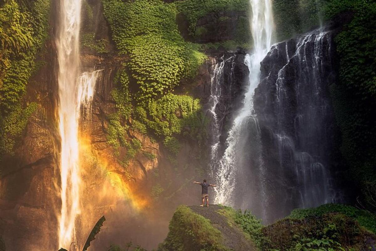 maður stendur fyrir framan foss