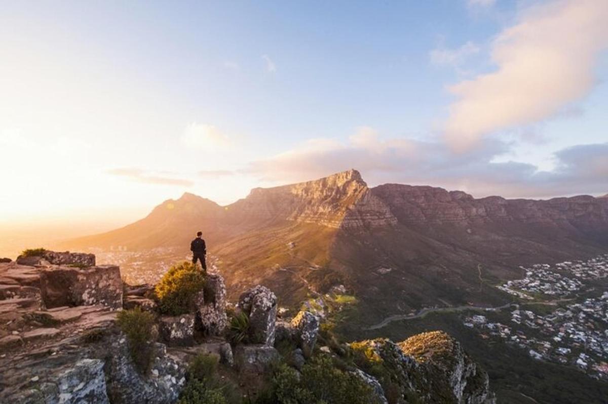 a man standing on top of a mountain at sunset