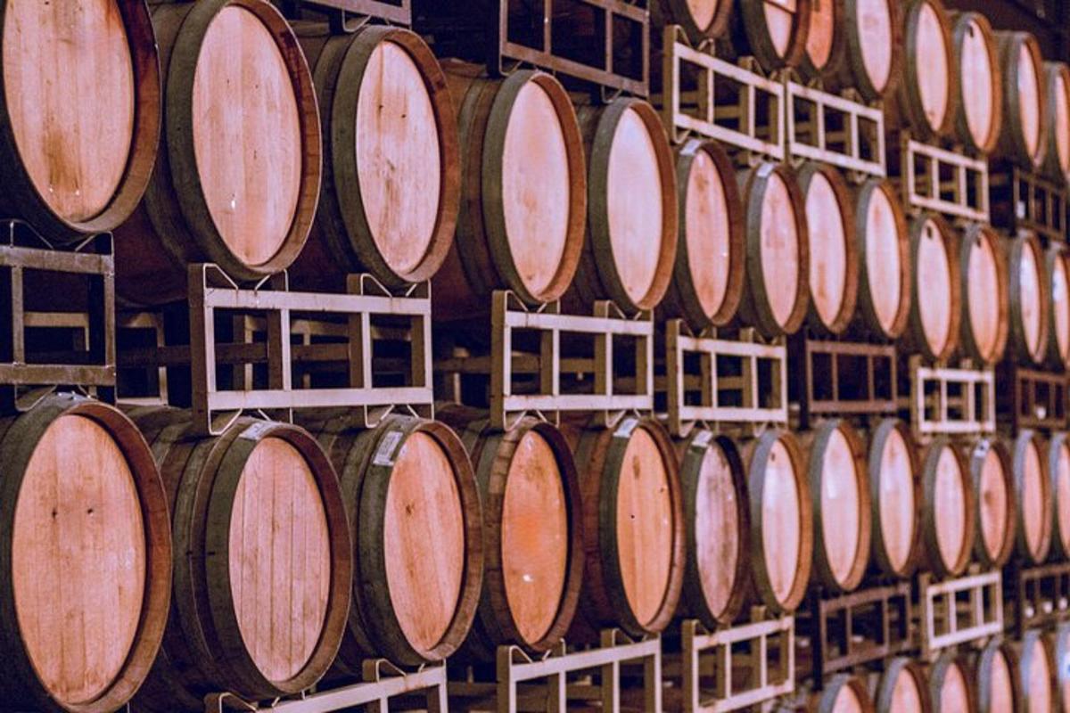 un mucchio di botti di vino allineate in un muro