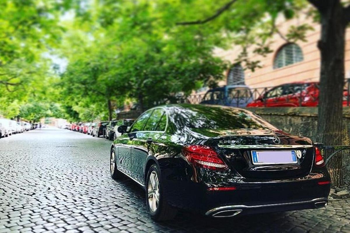 o mașină neagră parcată pe o stradă pietruită