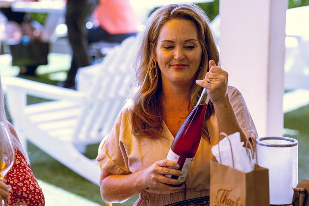 una donna tiene in mano una bottiglia di vino