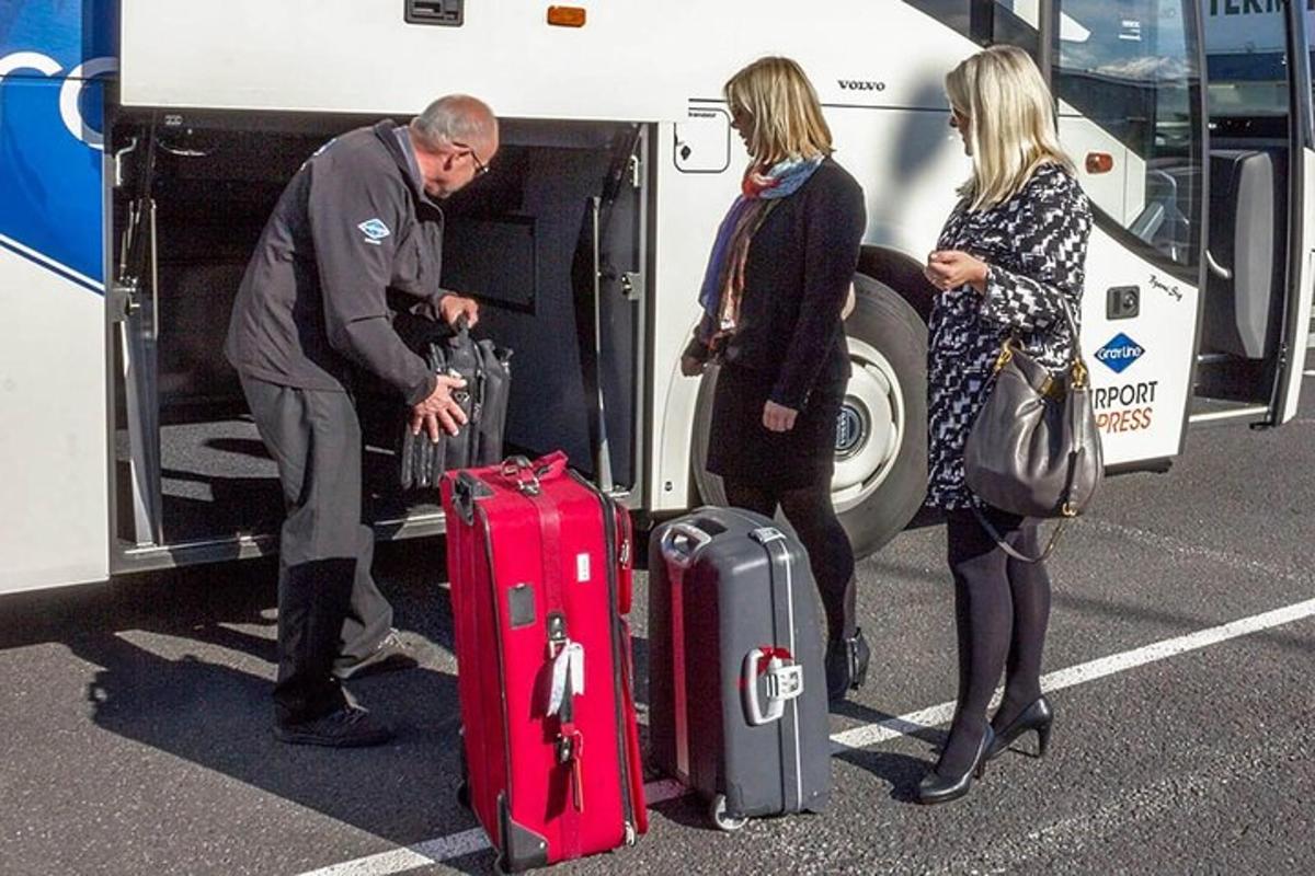 egy férfi és két nő csomagokat pakol a buszra