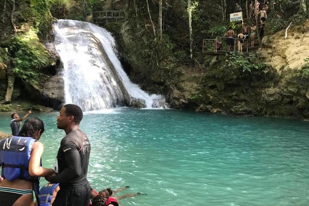 un gruppo di persone in piedi davanti a una cascata