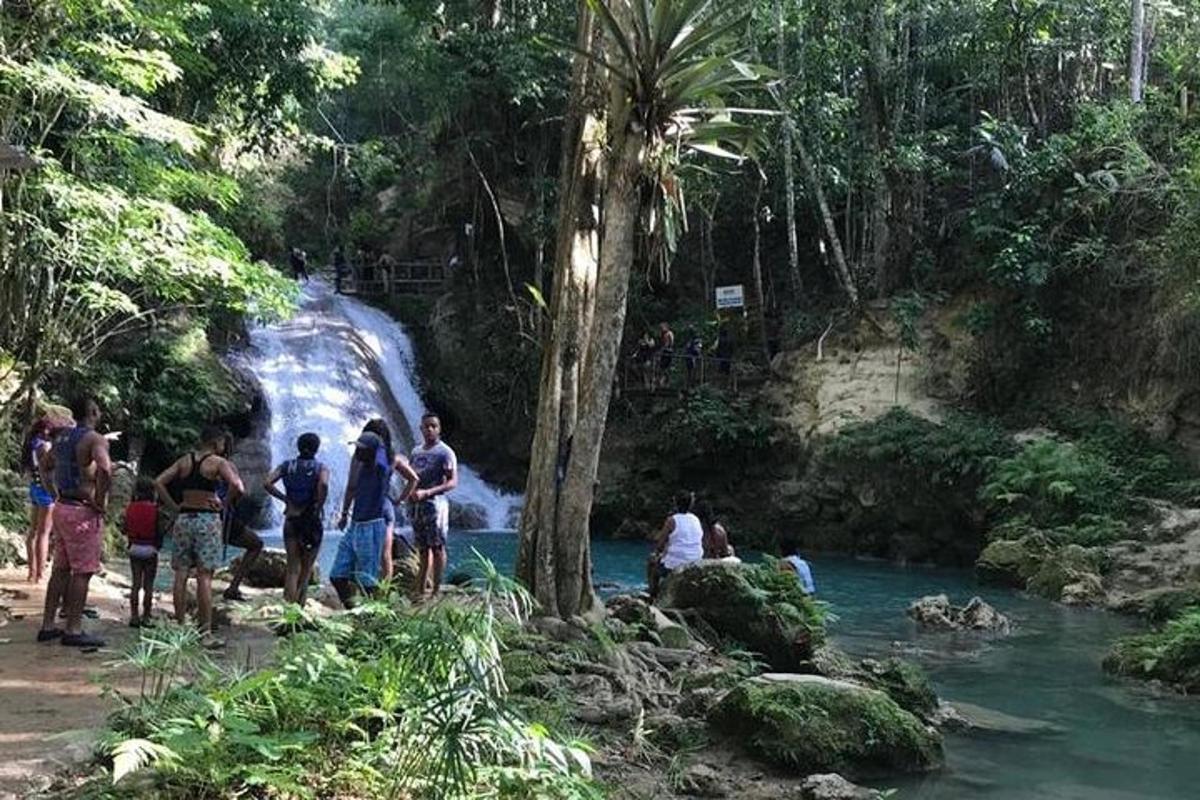 un gruppo di persone in piedi davanti a una cascata