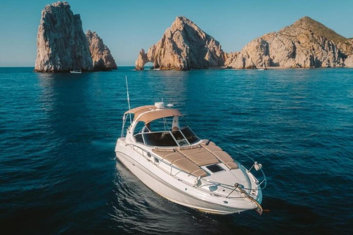 um barco branco na água com pedras ao fundo
