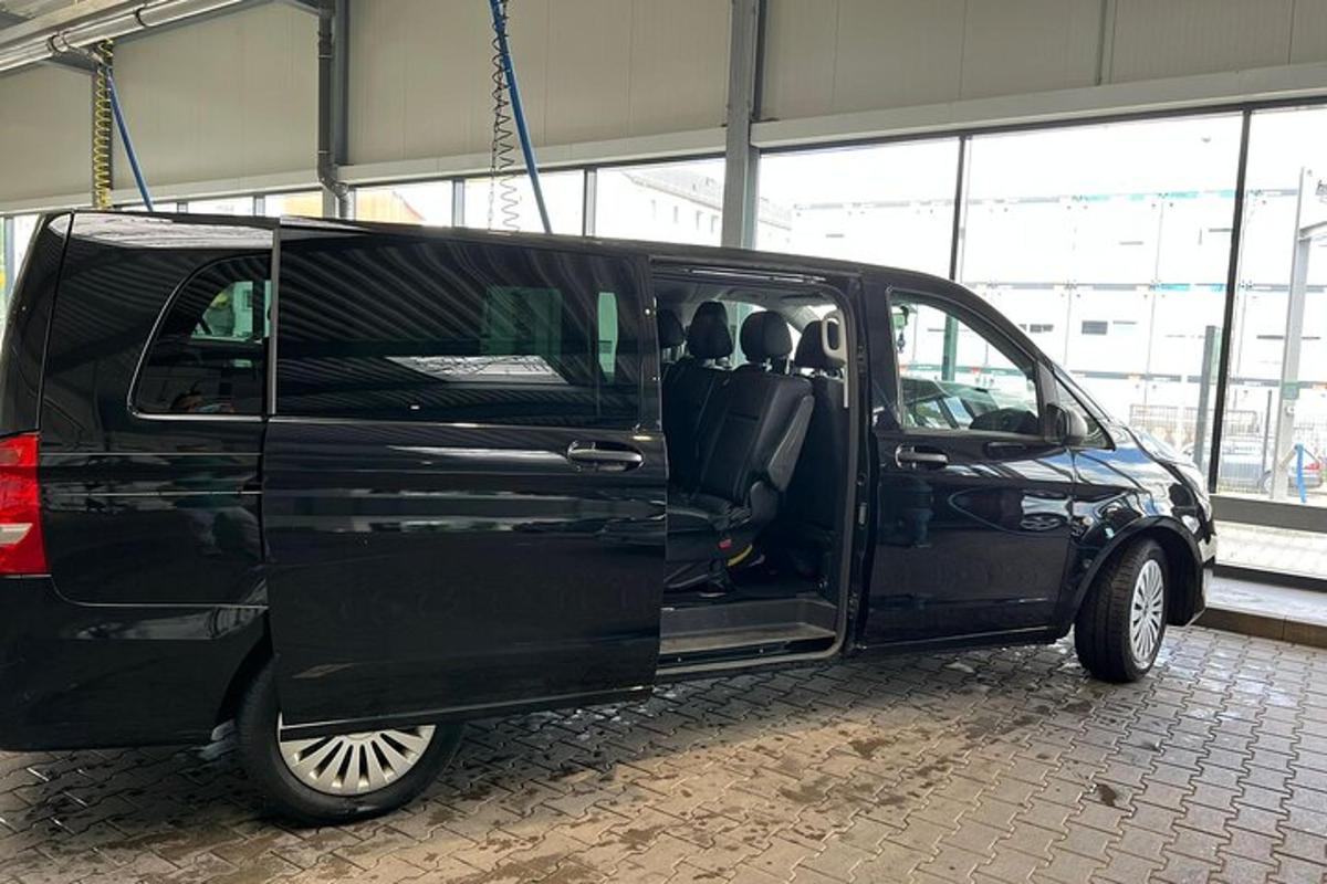 ein schwarzer Lieferwagen, der mit offenen Türen in einem Gebäude geparkt ist