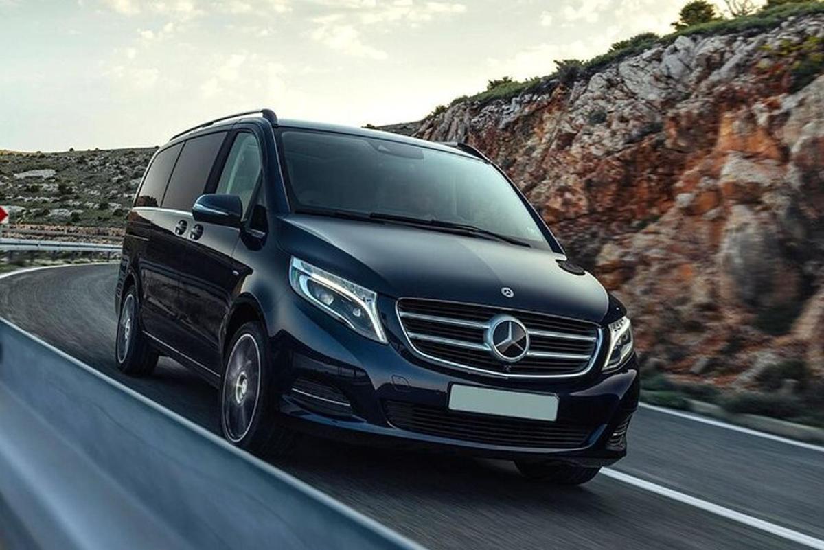 pa ceļu brauc melns Mercedes Benz furgons