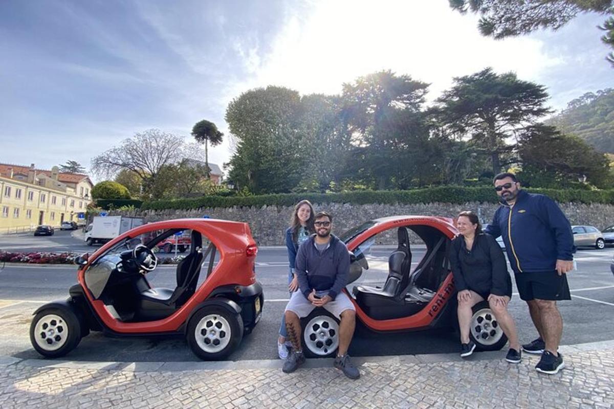 Un grupo de personas posando para una foto junto a un coche.