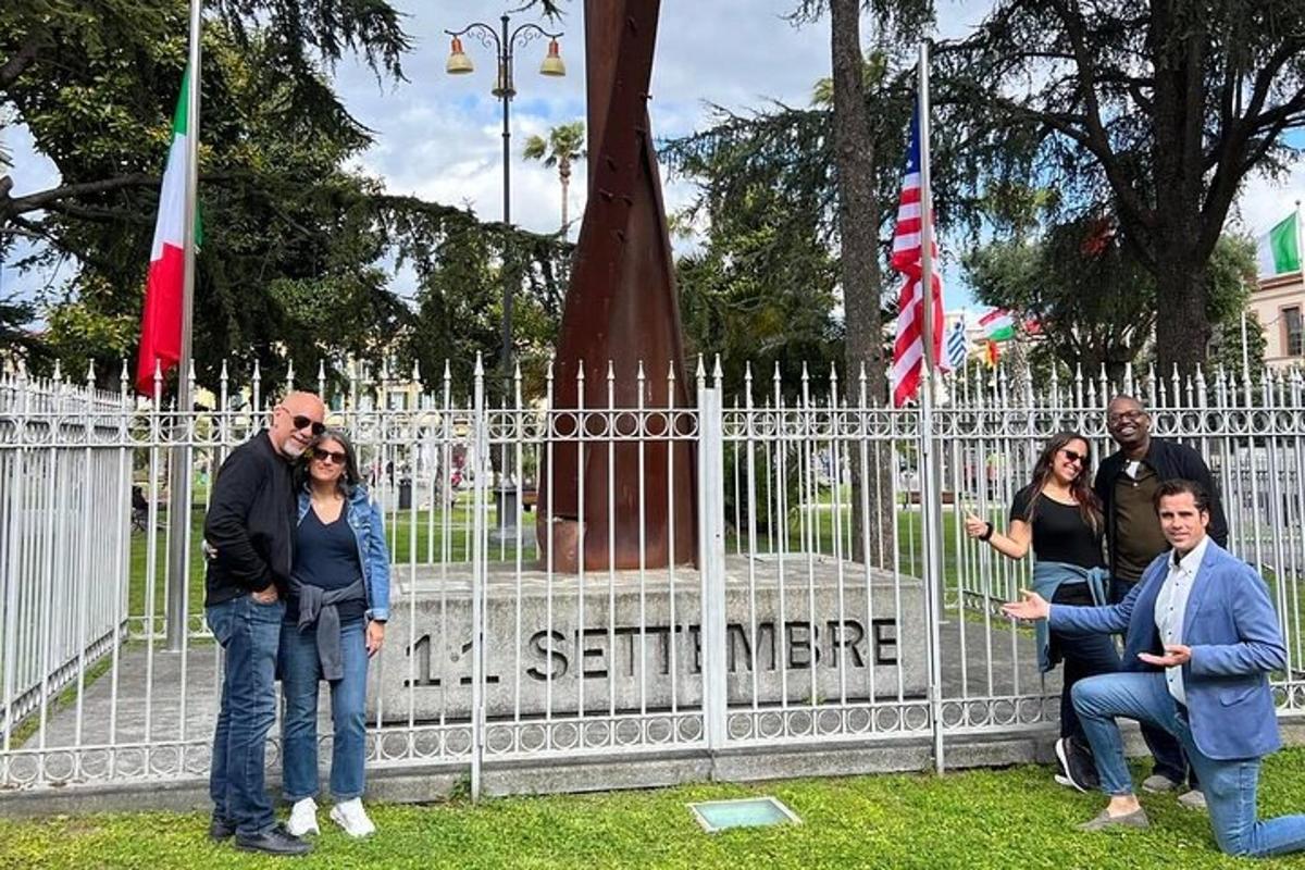 a group of people standing next to a fence with flags