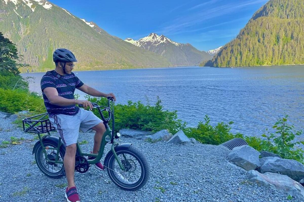 a man is sitting on a bike next to a lake