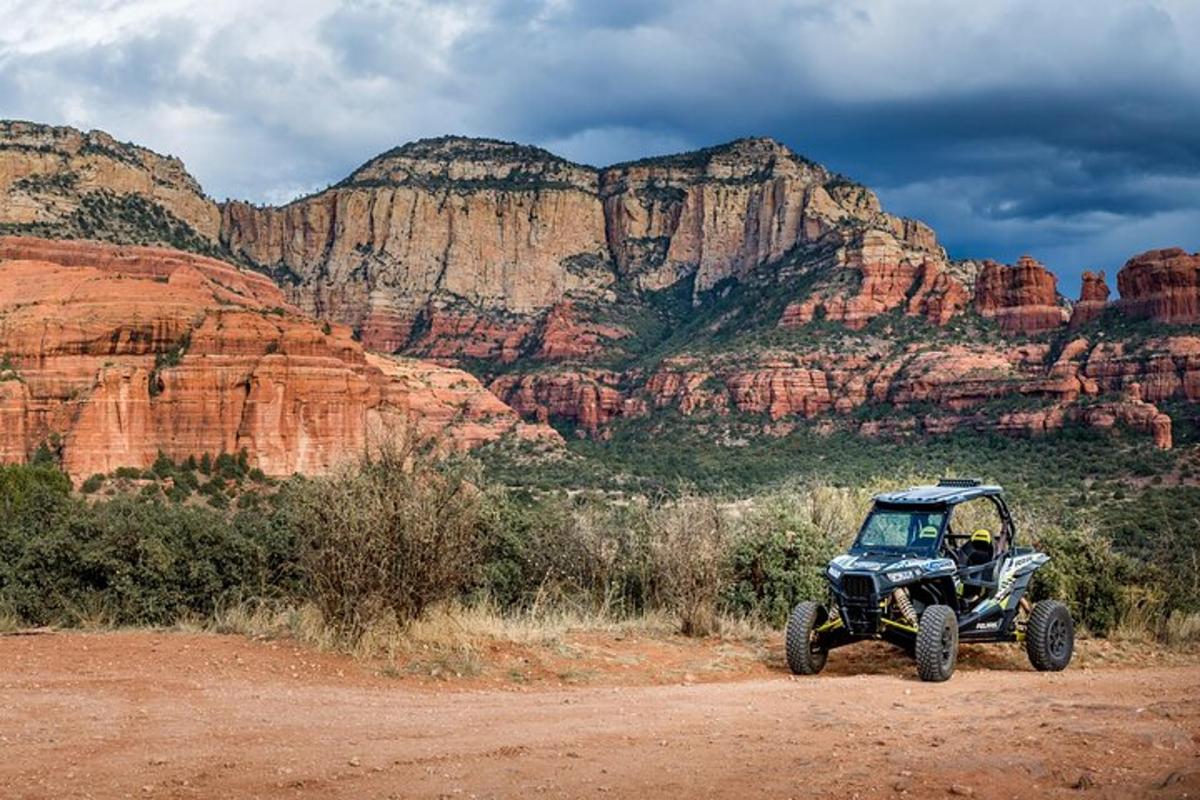 um quadriciclo estacionado em uma estrada de terra perto de uma montanha