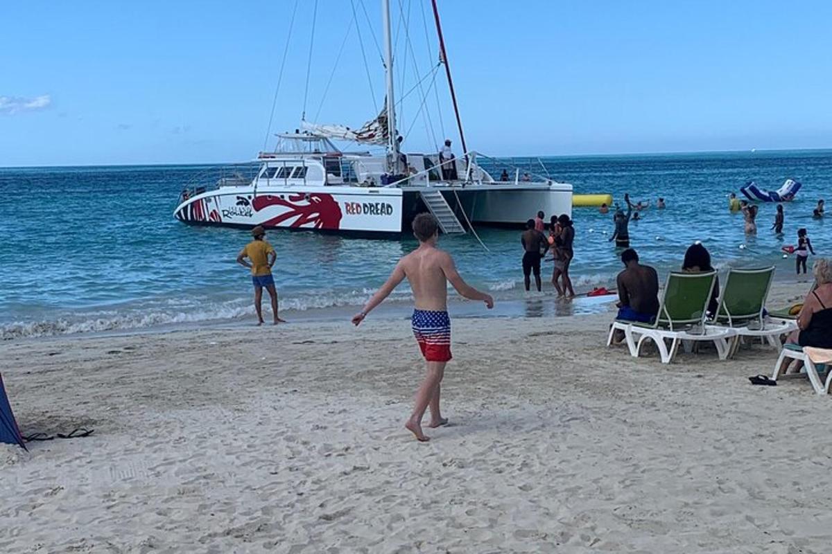 un grupo de personas en una playa con un barco