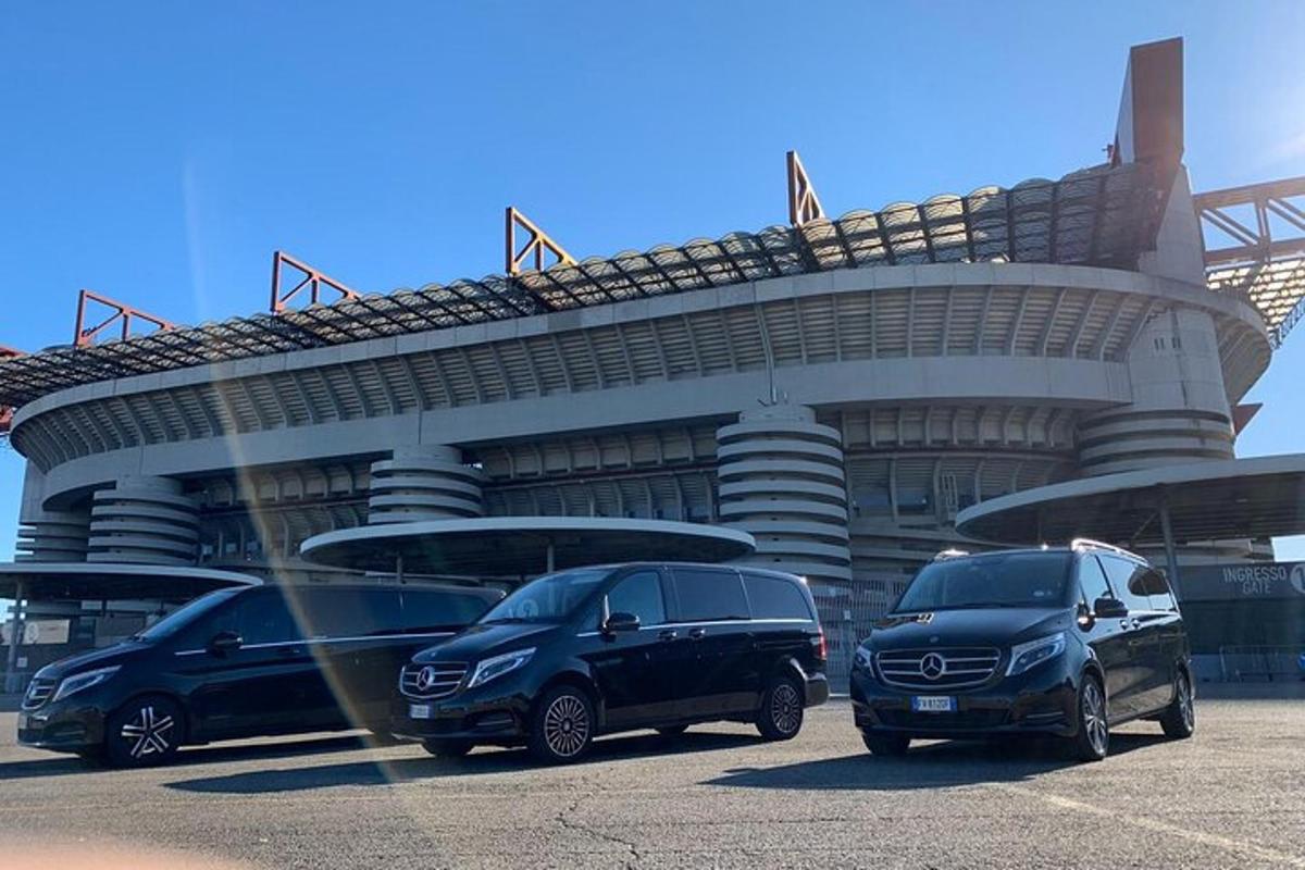 three cars parked in front of a stadium