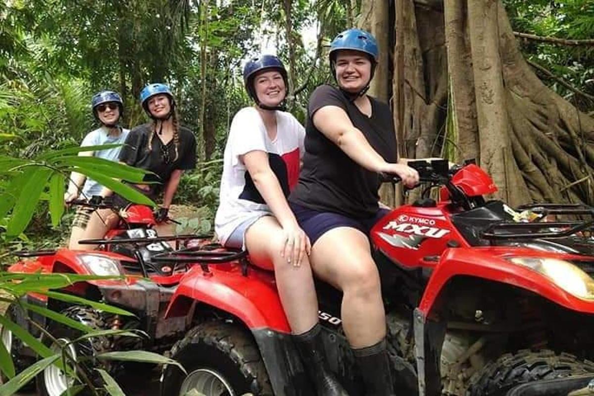 un gruppo di persone che guidano quad nella foresta