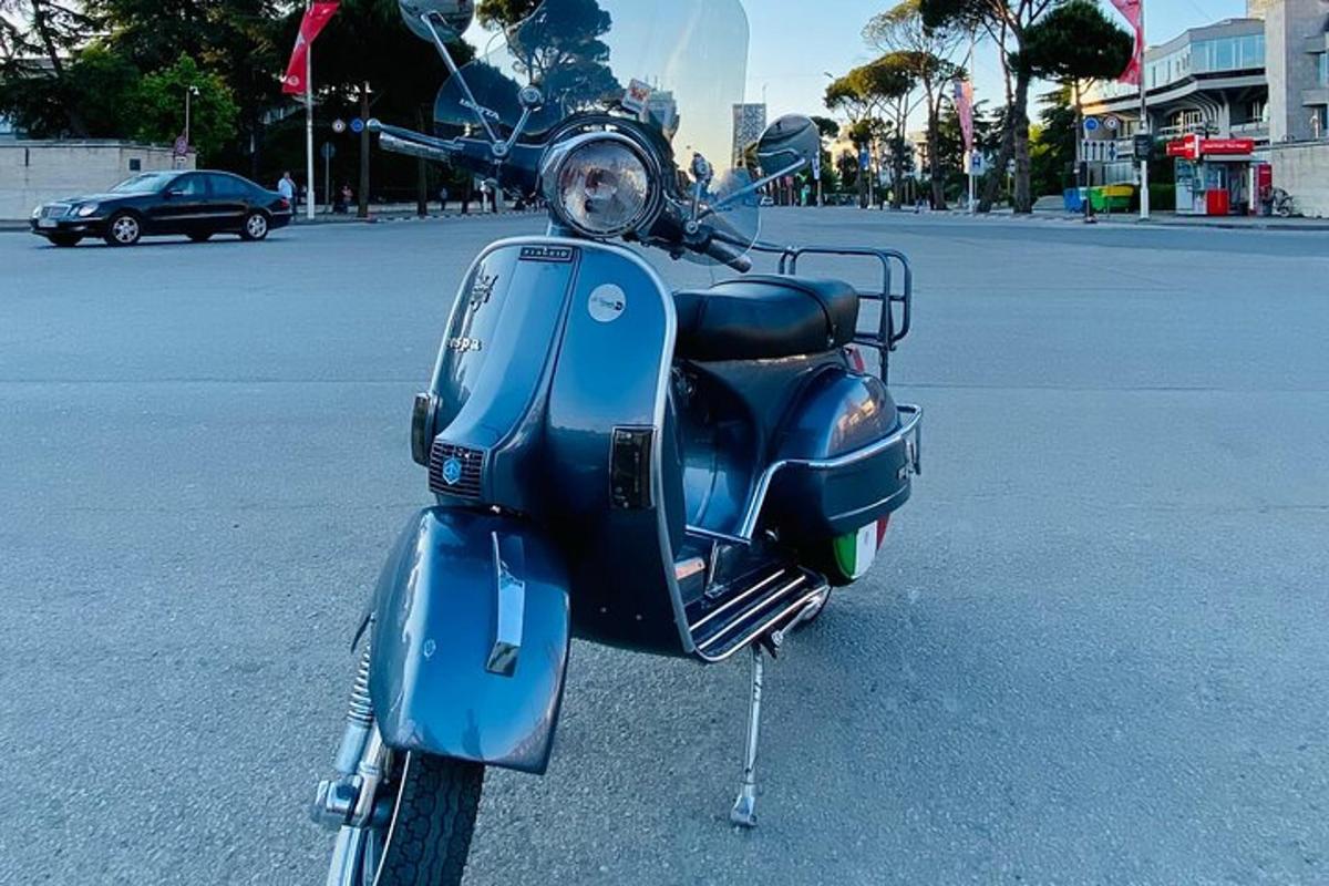 Blár vespa lagður á bílastæði