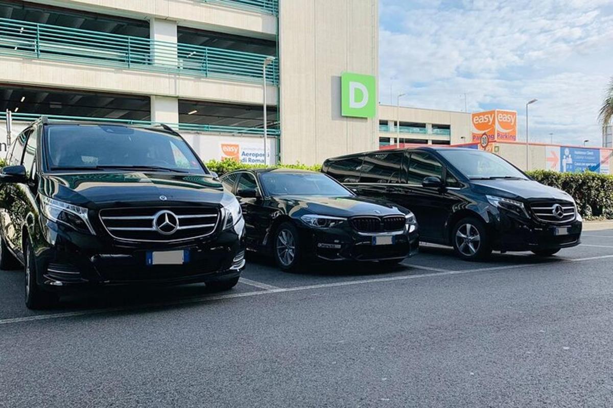tiga mobil diparkir di tempat parkir di depan sebuah gedung