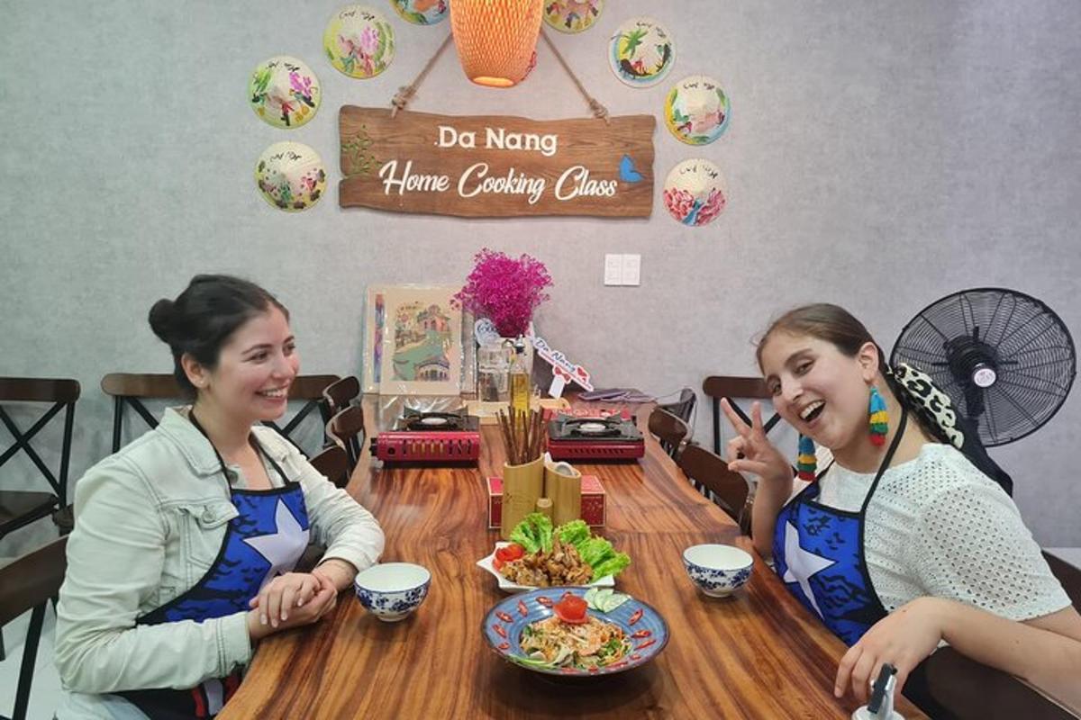 twee vrouwen zitten aan een tafel met eten