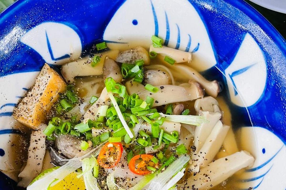 een blauwe kom soep met groenten en champignons