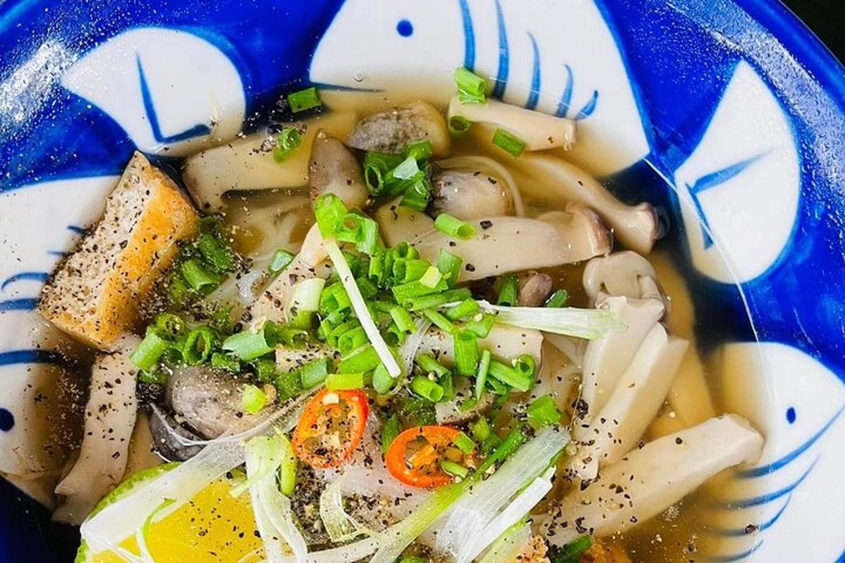 een blauwe kom soep met groenten en champignons