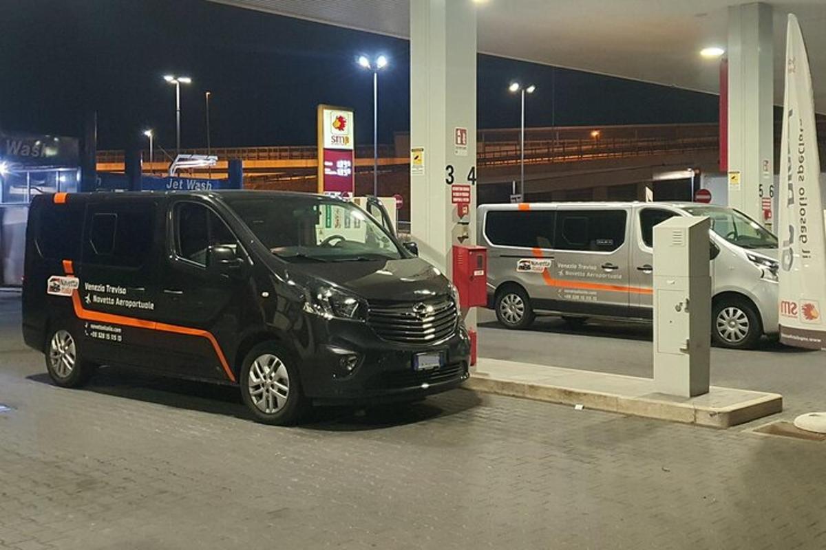 un furgone nero parcheggiato in una stazione di servizio di notte