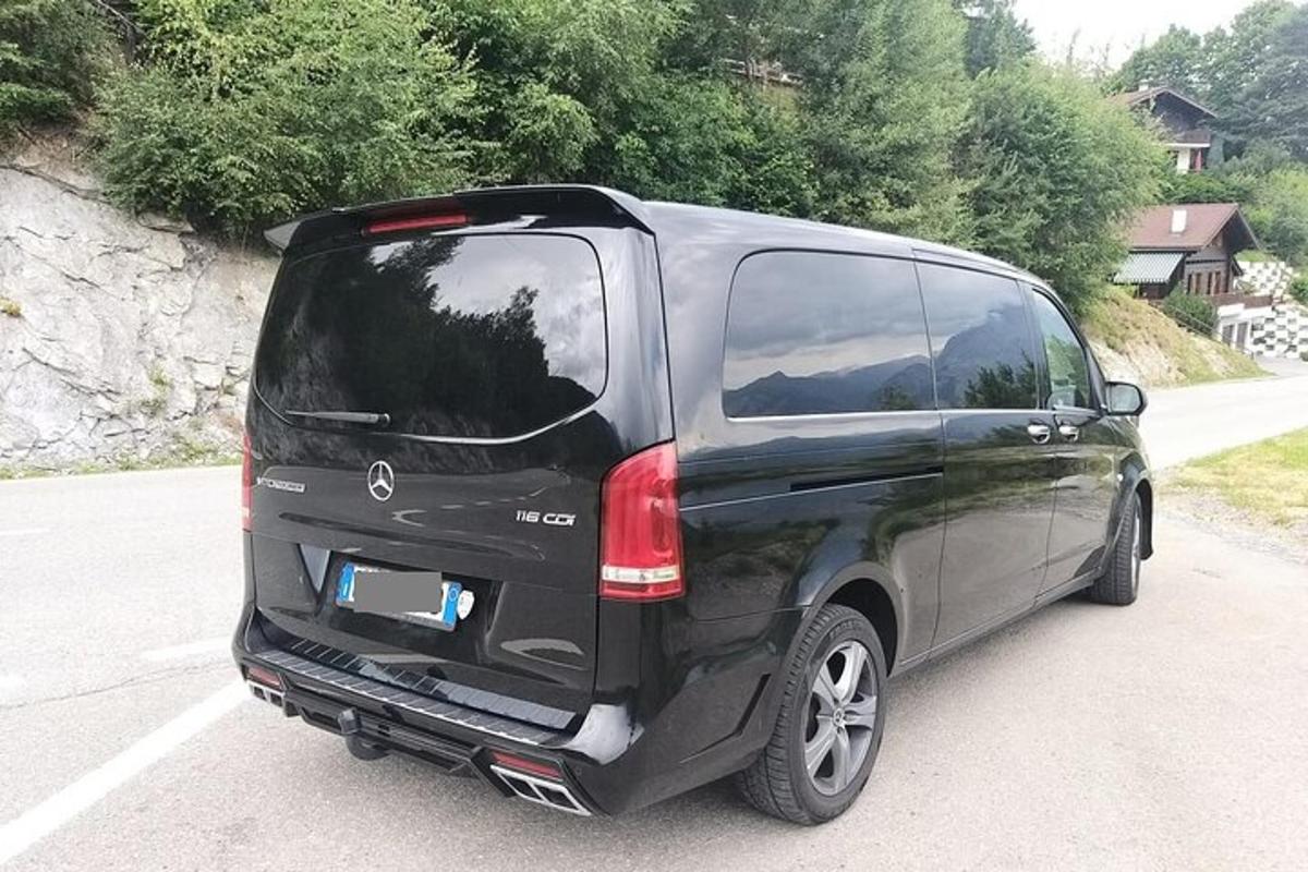 en svart varebil parkert på en parkeringsplass
