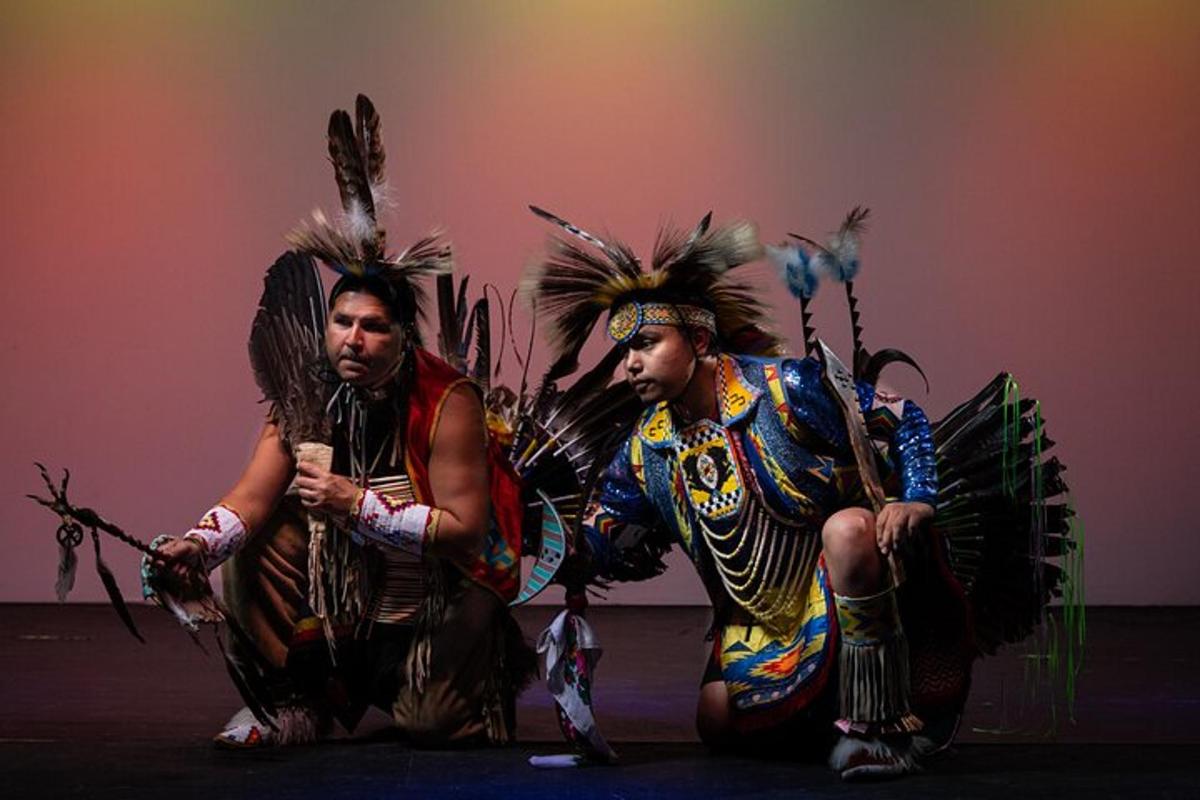 two men in indian costumes sitting on the ground