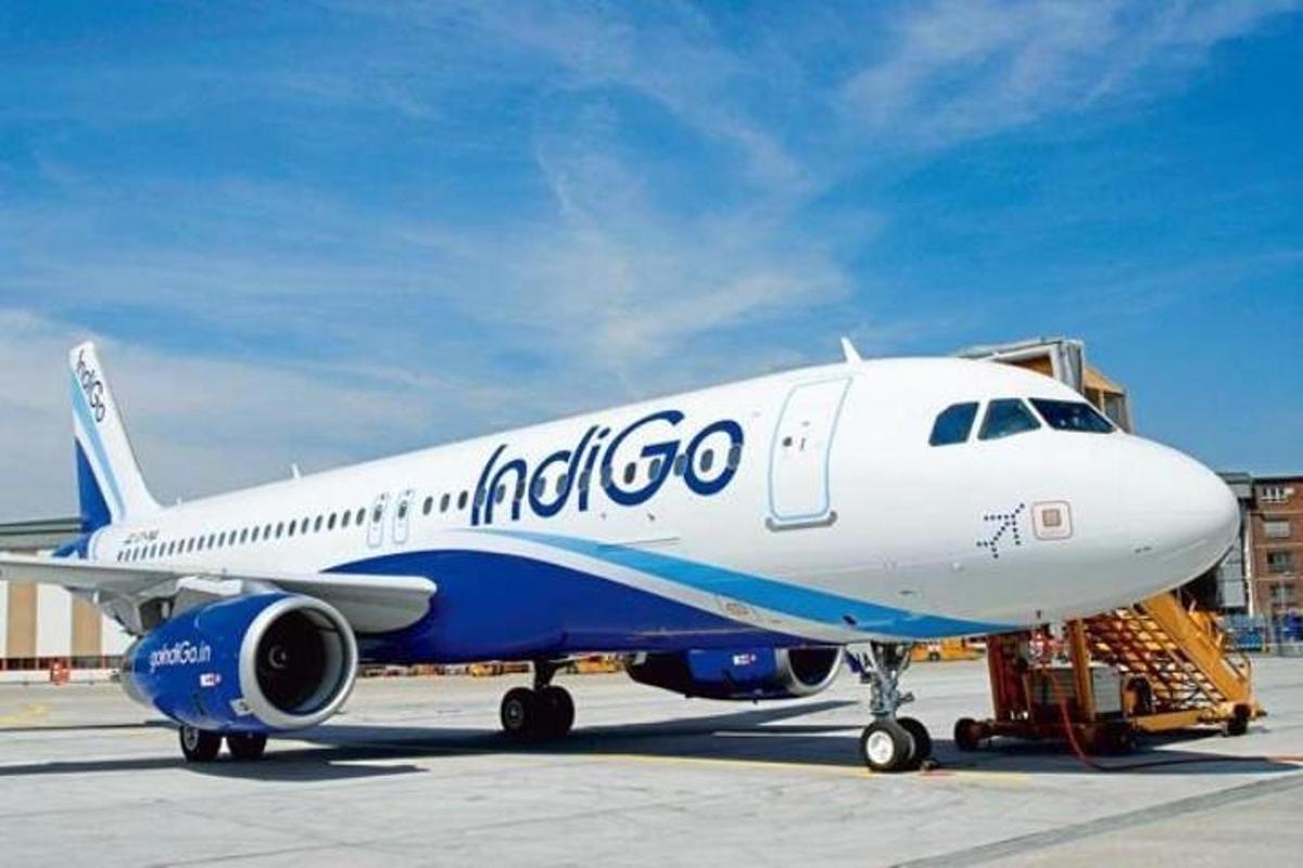 a blue and white airplane sitting on a runway