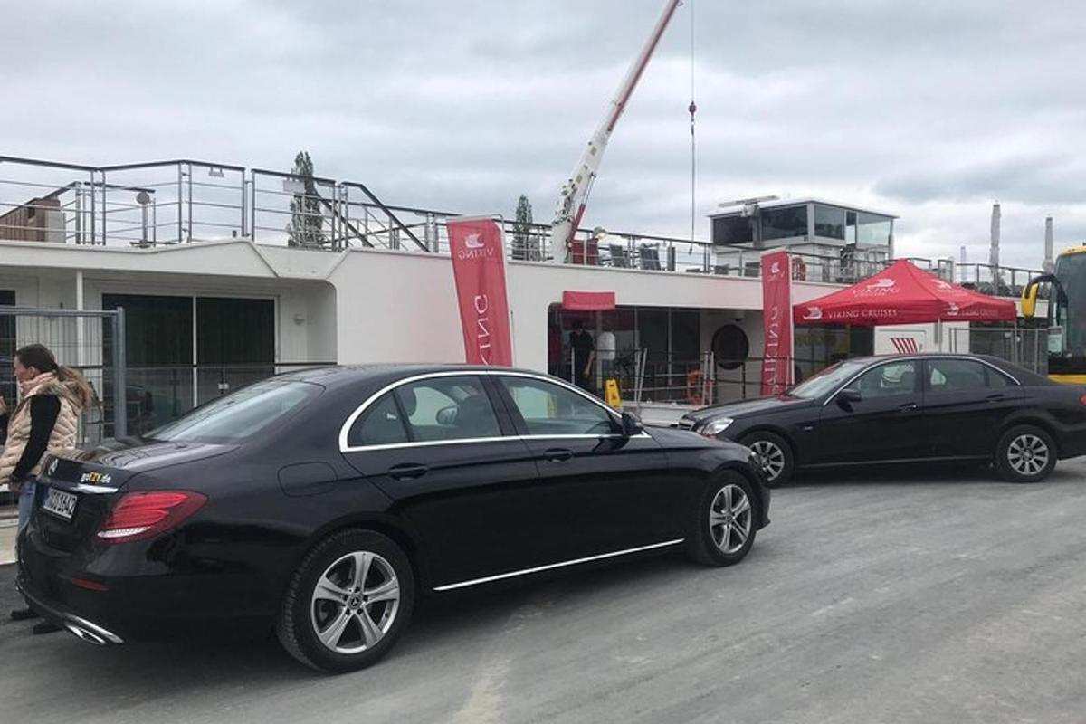 Dos coches estacionados en un estacionamiento frente a un edificio.