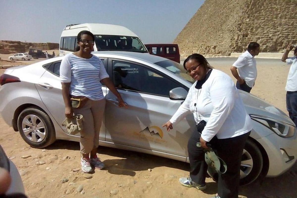seorang lelaki dan seorang wanita berdiri di sebelah kereta perak