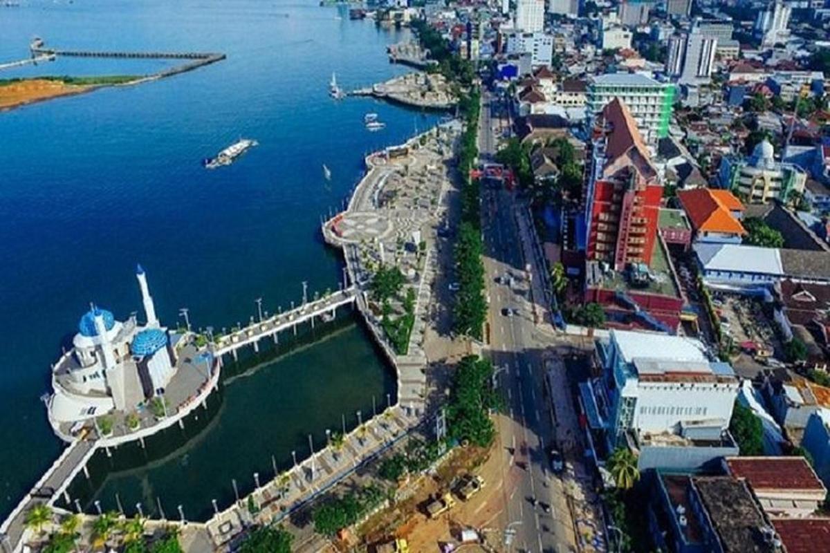 an aerial view of a city with a bridge over the water