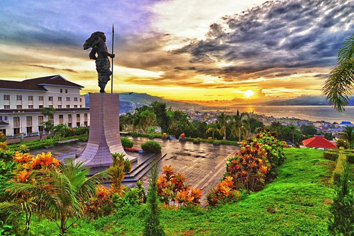 a statue in front of a building with a sunset