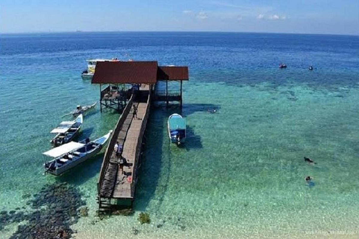 a dock in the ocean with boats in the water