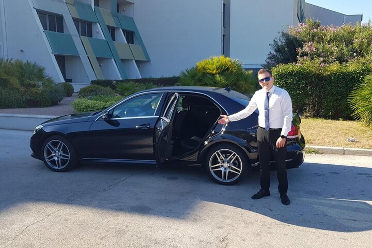 um homem está parado ao lado de um carro preto