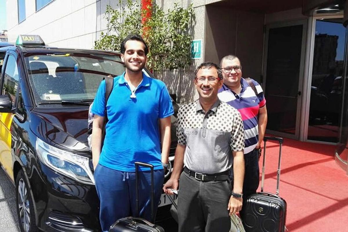 un gruppo di tre uomini in piedi accanto a un'auto