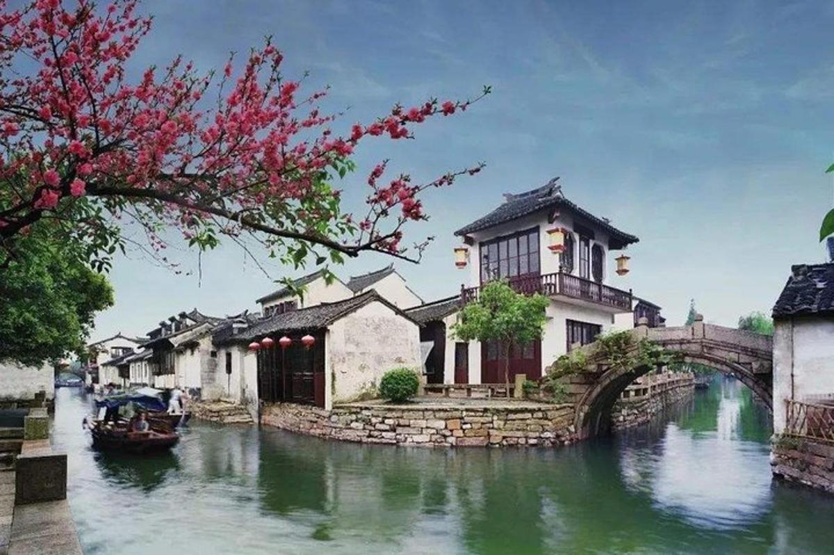 a river with houses and a bridge with a boat