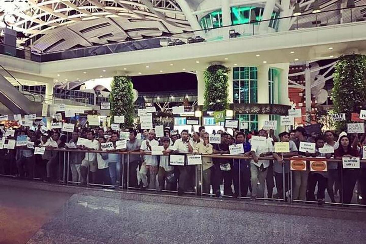a group of people holding up signs in a building