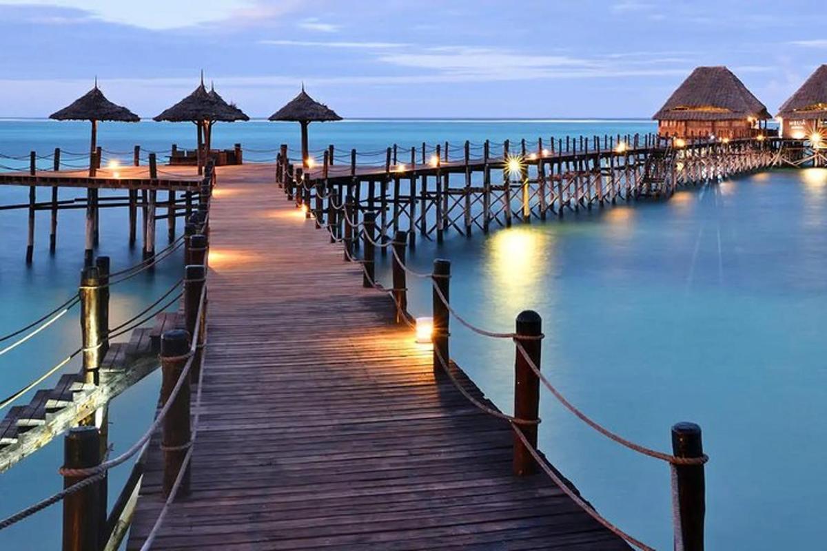 ein Pier mit Sonnenschirmen auf dem Wasser bei Nacht