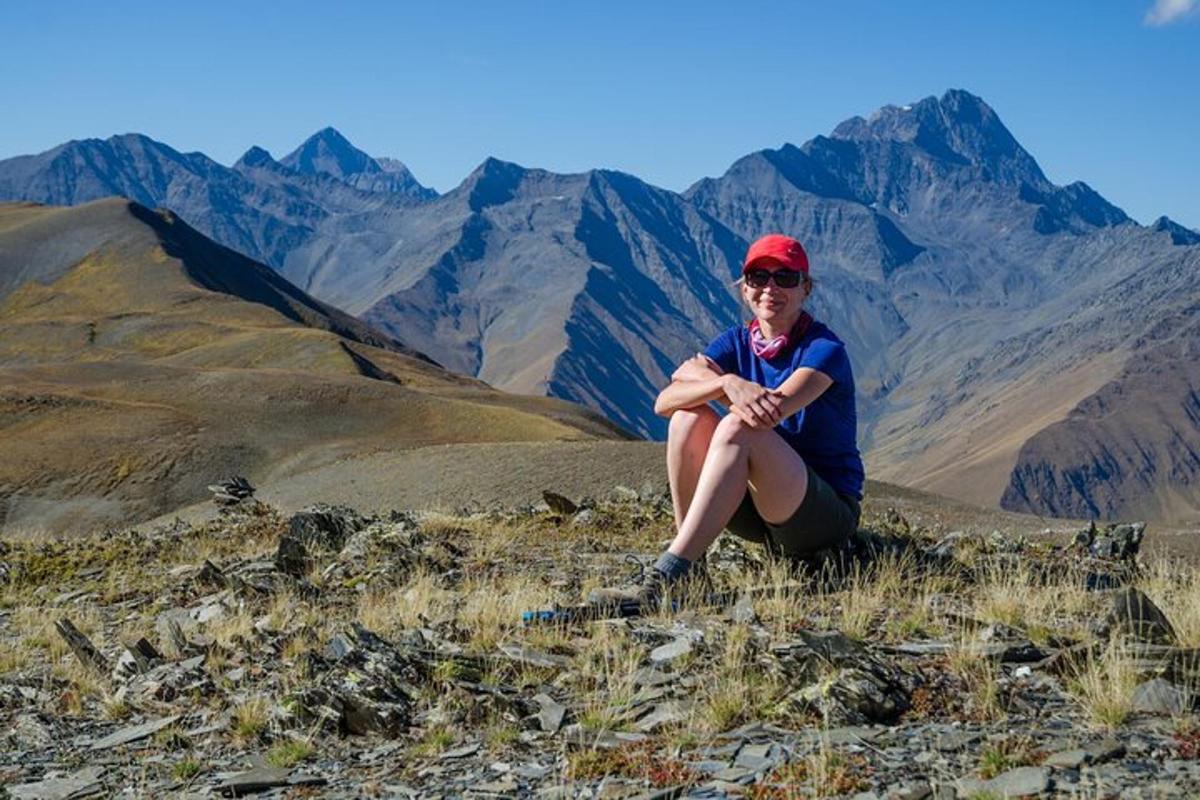 a woman sitting on the top of a mountain