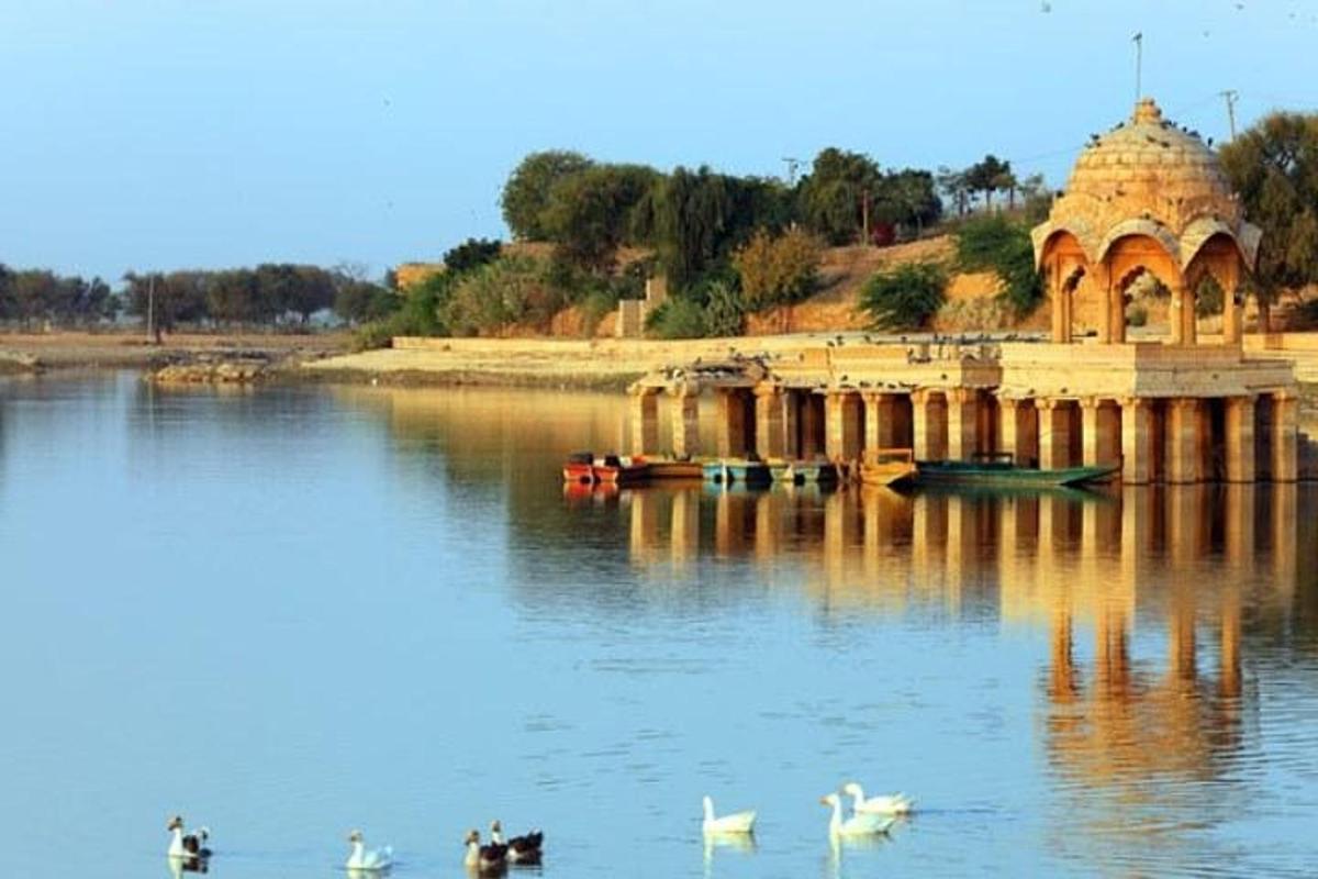 a building on a lake with swans in the water