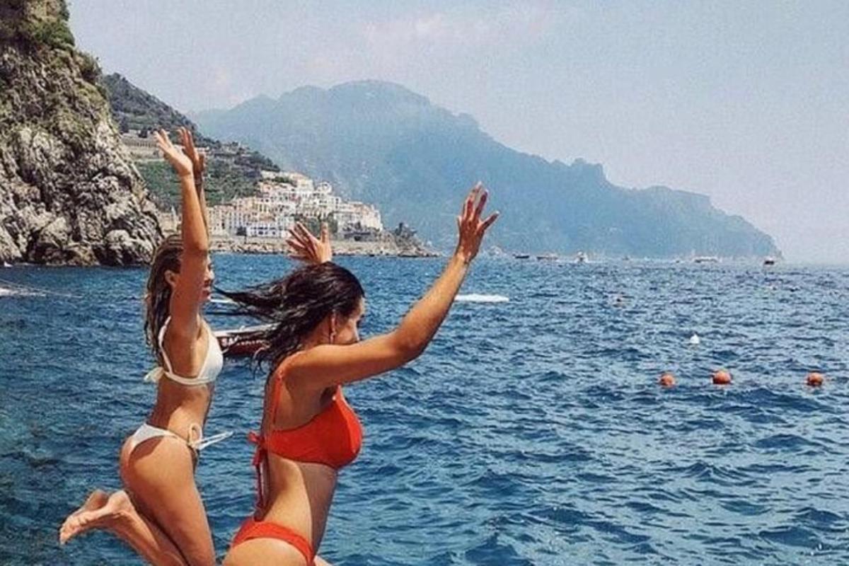 dua gadis melompat ke dalam air di pantai