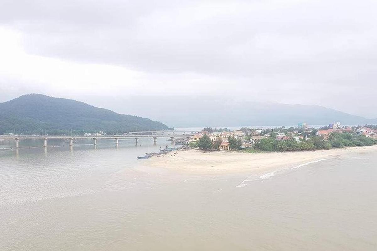 a body of water with a beach and a bridge