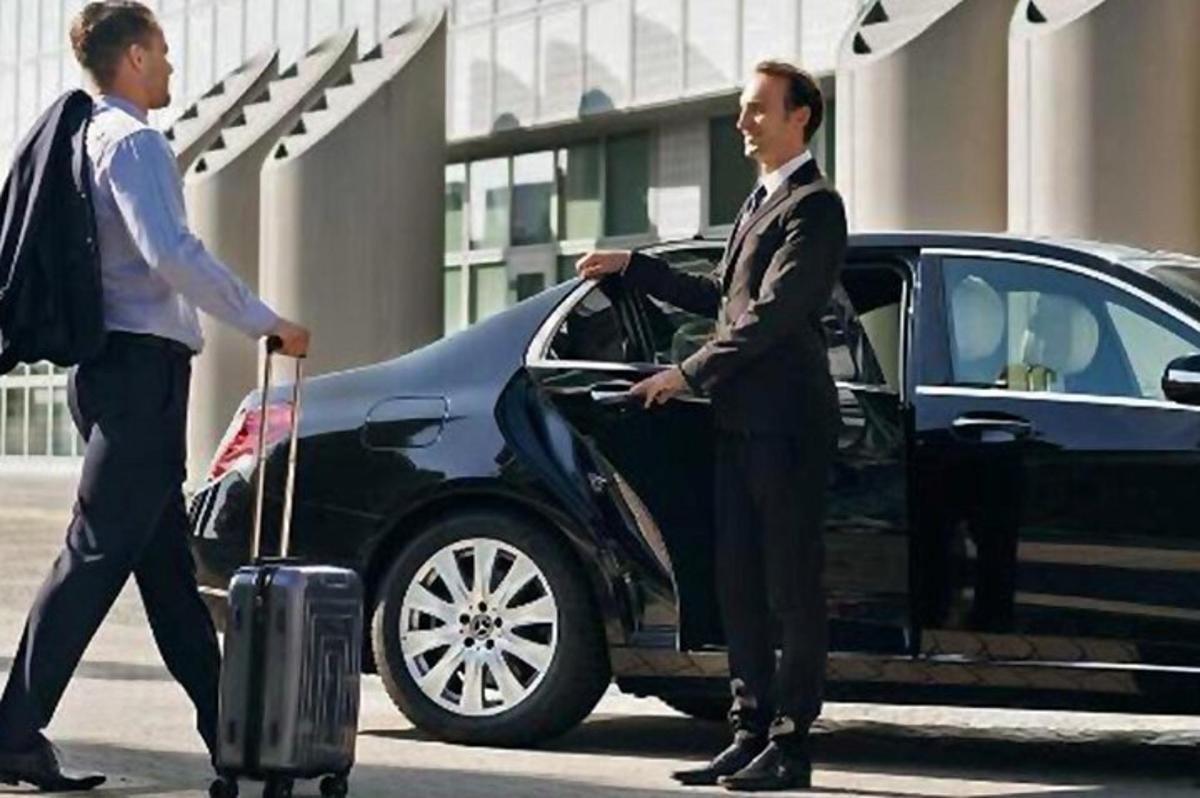 un uomo con una valigia che scende da un'auto