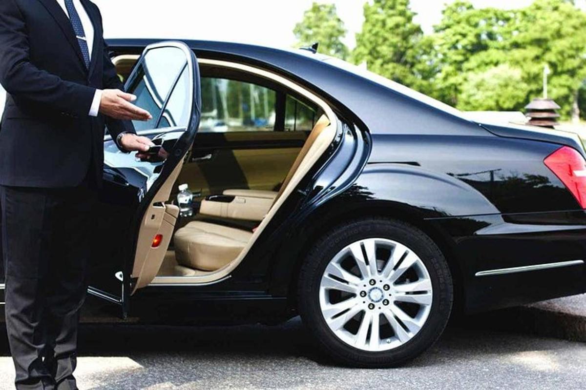 puvussa oleva mies nousee autoon