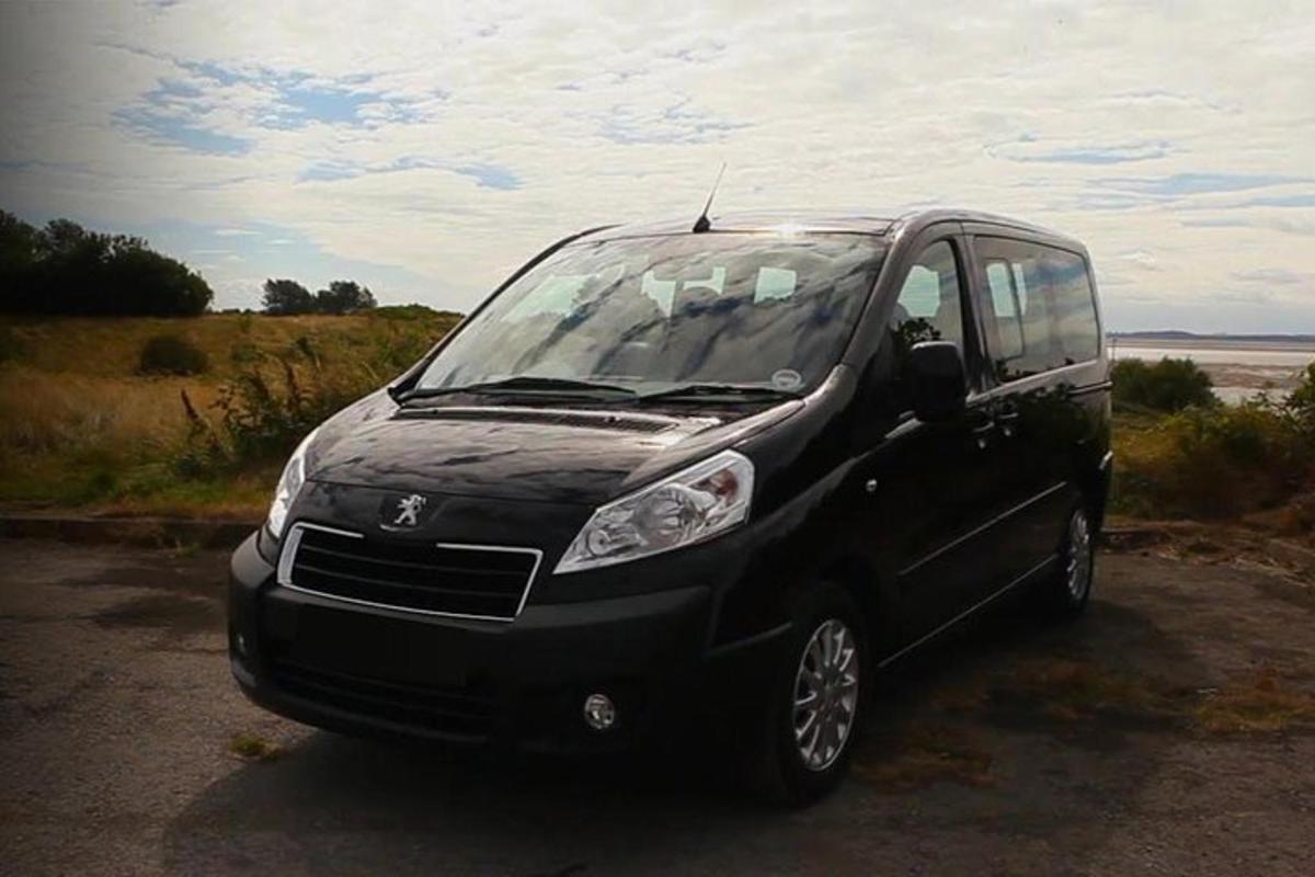 a small black car parked in a parking lot