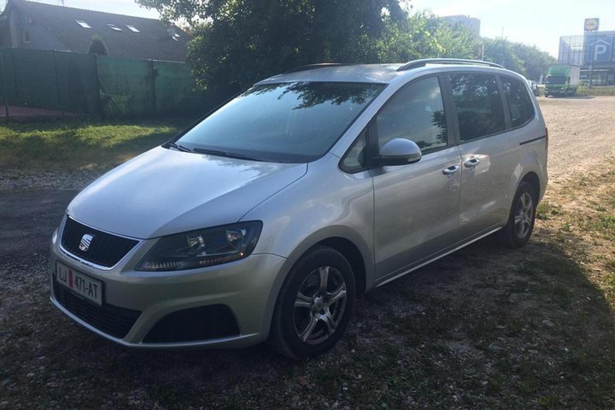 bel kombi parkiran na travi na polju