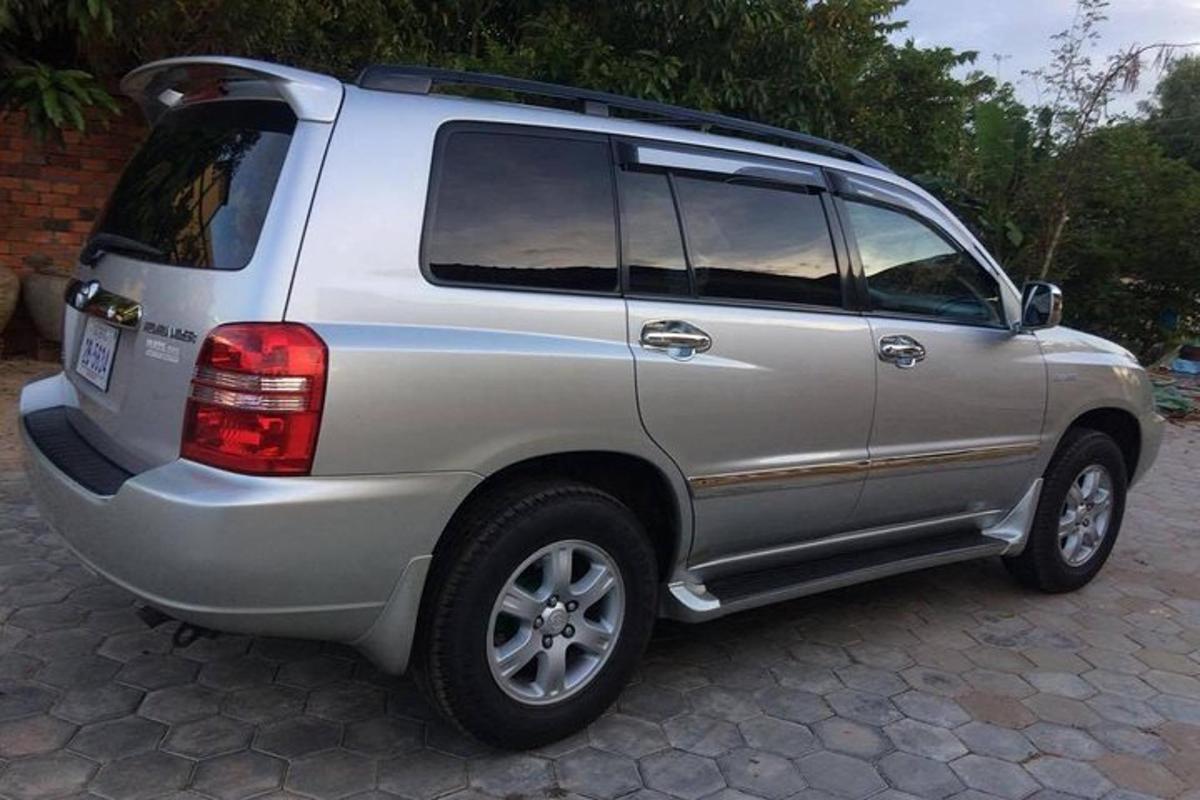 Un SUV argintiu este parcat pe un drum pietruit