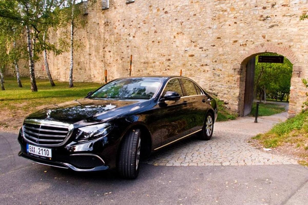 černé auto zaparkované před kamennou zdí