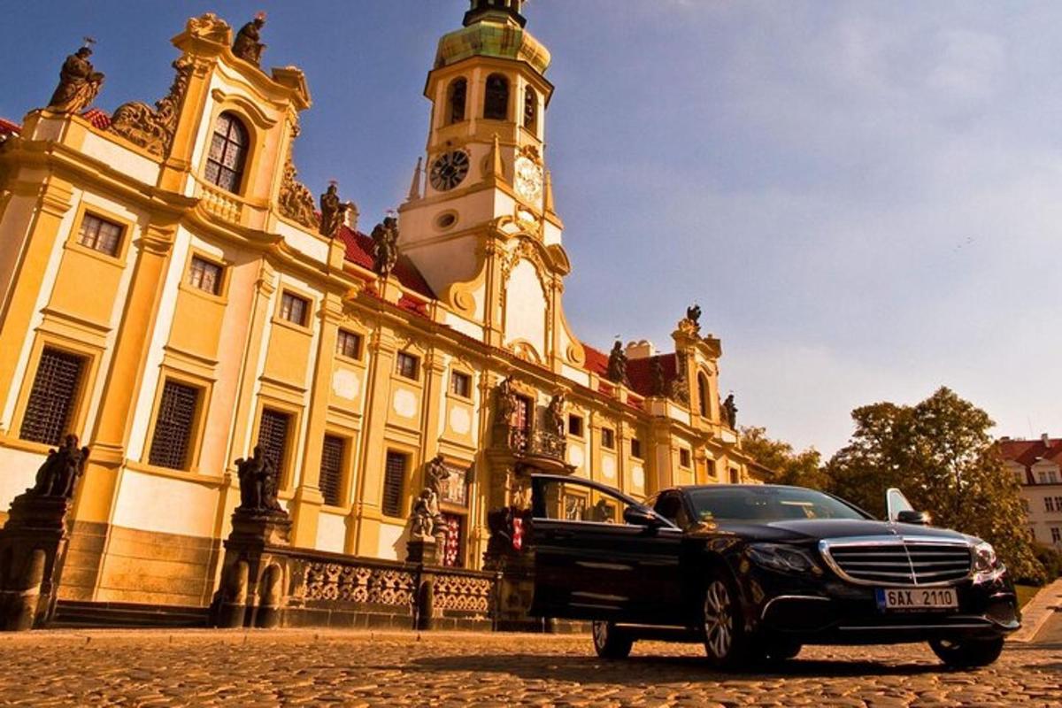černé auto zaparkované před budovou s hodinovou věží