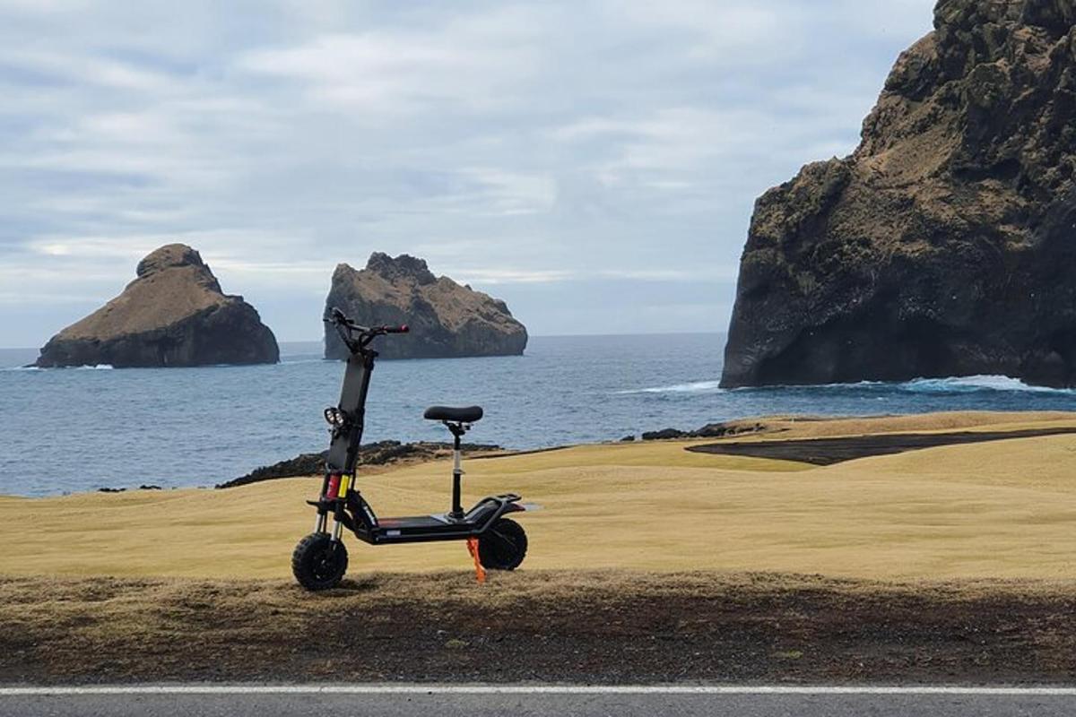 a scooter parked on the beach next to the ocean
